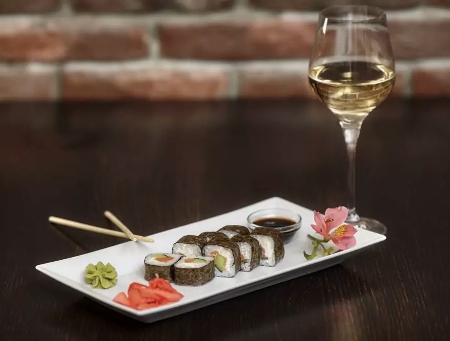 Sushi rolls served alongside a glass of AJA wine