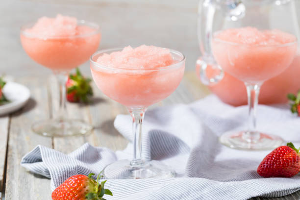 A glass of rosé wine cocktail with fruit garnish