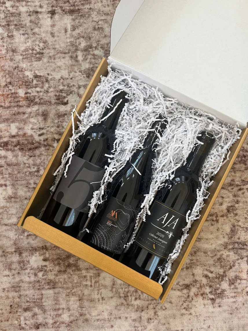 Three AJA red wines nestled in a kraft gift box
